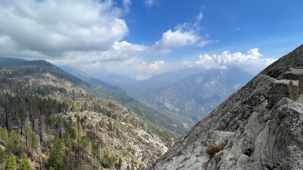 Beautiful clouds in blue skies floating above mountains as seen from Moro Rock in Sequoia National Park.