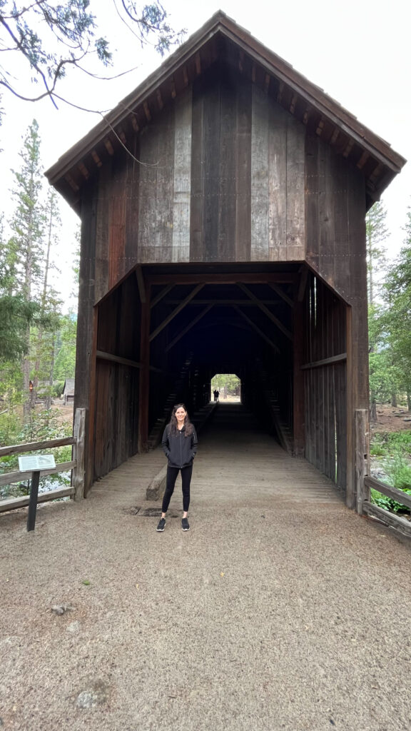 Me standing in front of the covered bridge in Yosemite History Center in Yosemite National Park