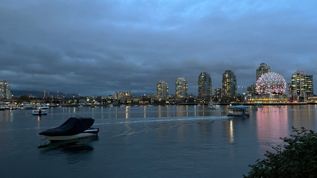 Science World lit up on the right as seen from The Seawall in Olympic Village in Vancouver, BC, Canada