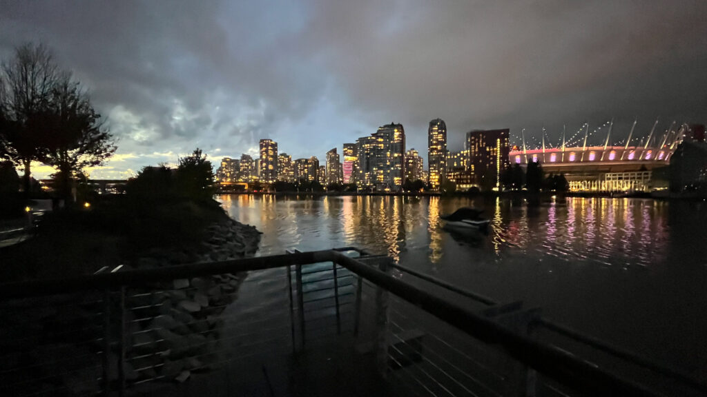 BC Place Stadium lit up on the right as seen from The Seawall in Olympic Village in Vancouver, BC, Canada