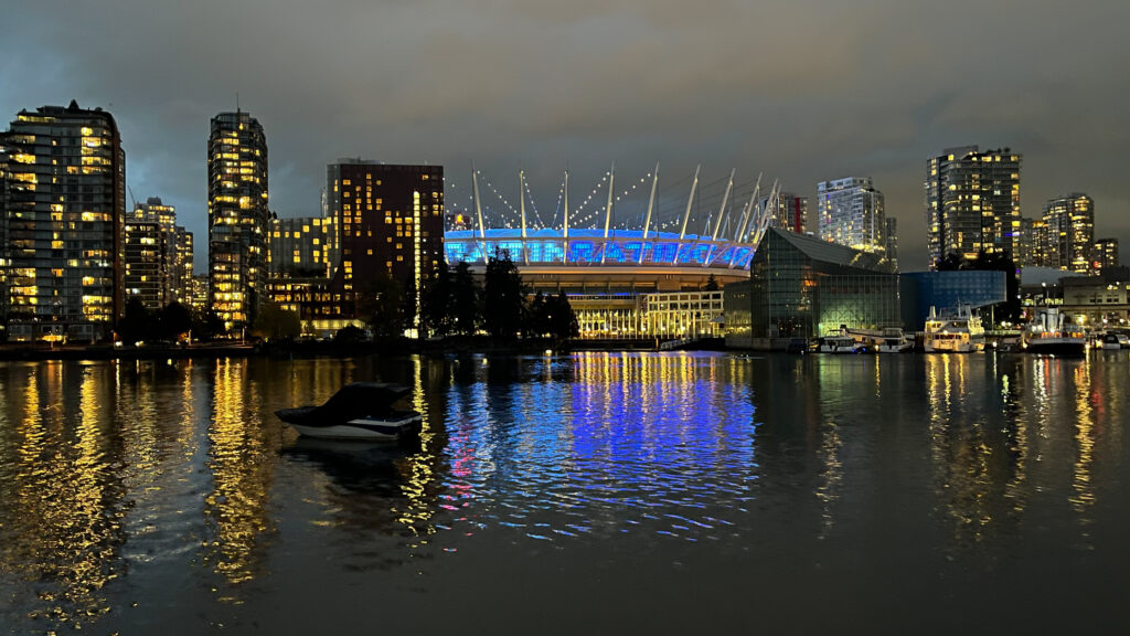 BC Place Stadium lit up in the center as seen from The Seawall in Olympic Village in Vancouver, BC, Canada