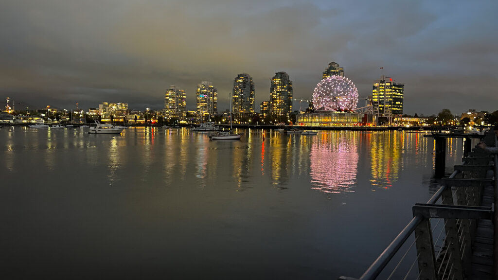 Science World lit up on the right as seen from The Seawall in Olympic Village in Vancouver, BC, Canada