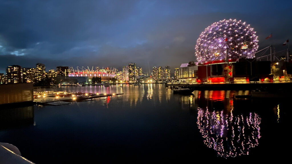 BC Place Stadium lit up on the left and Science World on the right as seen from The Seawall in Olympic Village in Vancouver, BC, Canada