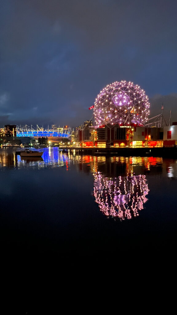 BC Place Stadium lit up on the left and Science World on the right as seen from The Seawall in Olympic Village in Vancouver, BC, Canada