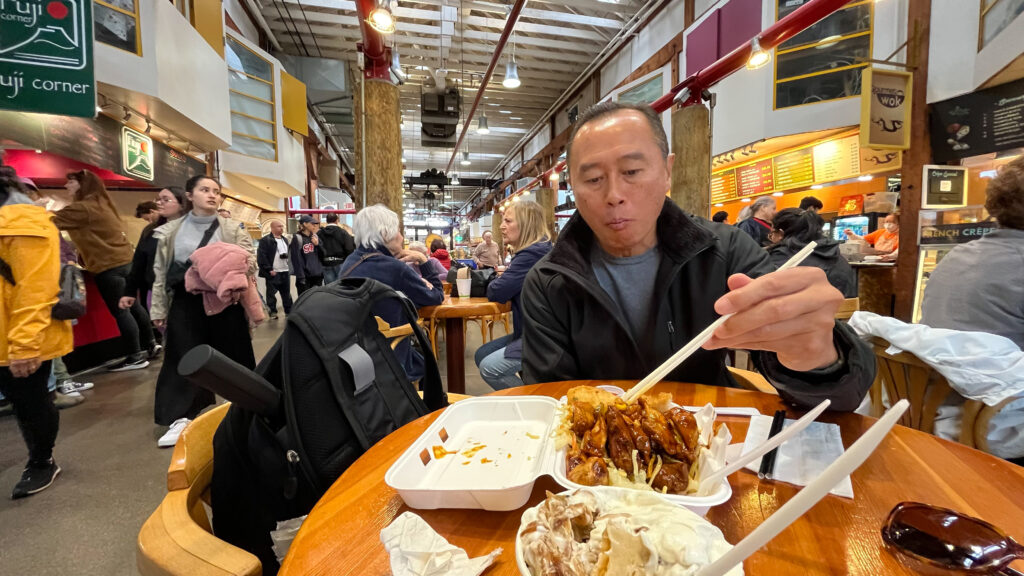 My husband trying to eat his bad Chinese food from Gourmet Wok while I enjoyed super yummy mini Perogies with sautèd onions & sour cream from Kaisereck Delicatessen (At Granville Island Public Market in Vancouver, BC, Canada)