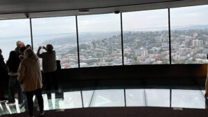 The 500 feet high observation level has a revolving glass floor. This level is just below the 520 feet high open-air viewing area with glass windows (Space Needle, Seattle, WA)