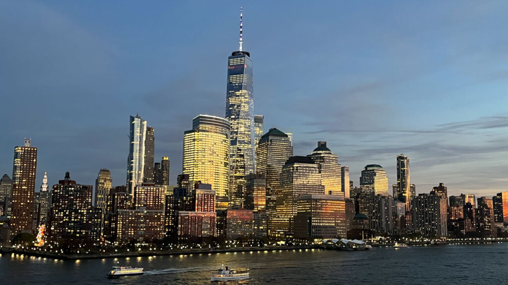 Sailing out of Manhattan, New York City, NY on the Carnival Venezia during sunset with One World Trade Center in the center