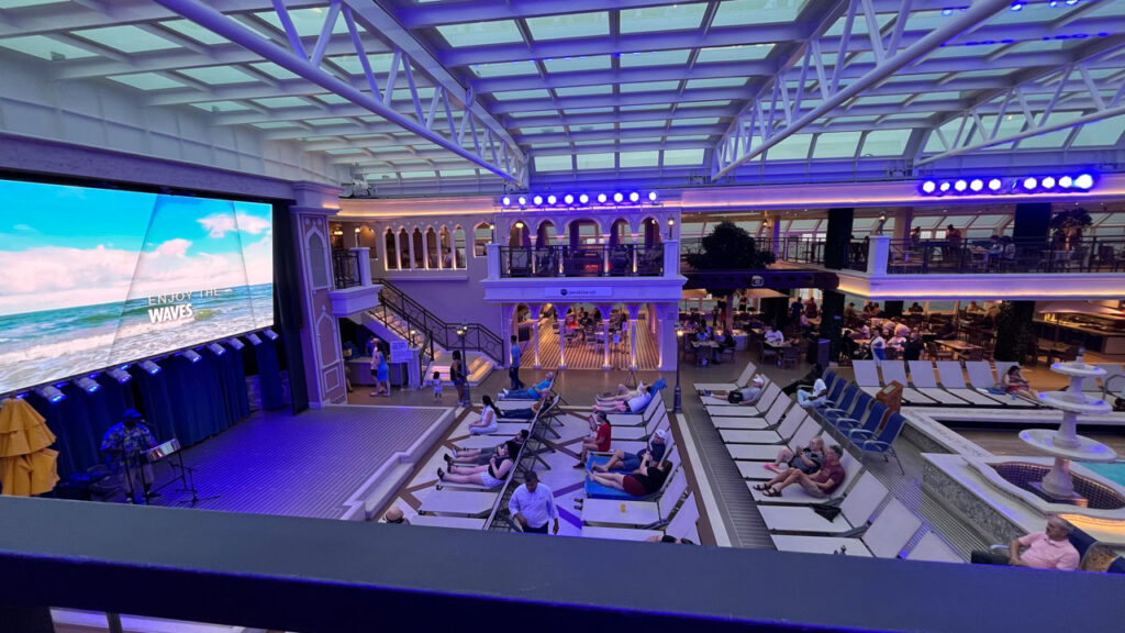 View of Lido Deck (deck 10) lounging area in front of the large LED movie screen from deck 11 balcony on the Carnival Venezia with the magradome covering decks 10 and 11