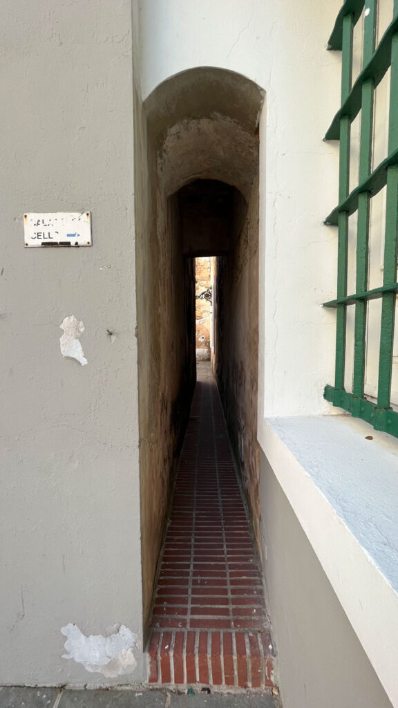 The narrow passage from the back patio of the Puerto Rico Tourism Company on Paseo de la Princesa in San Juan, Puerto Rico leads to an old, small prison that you can tour for free